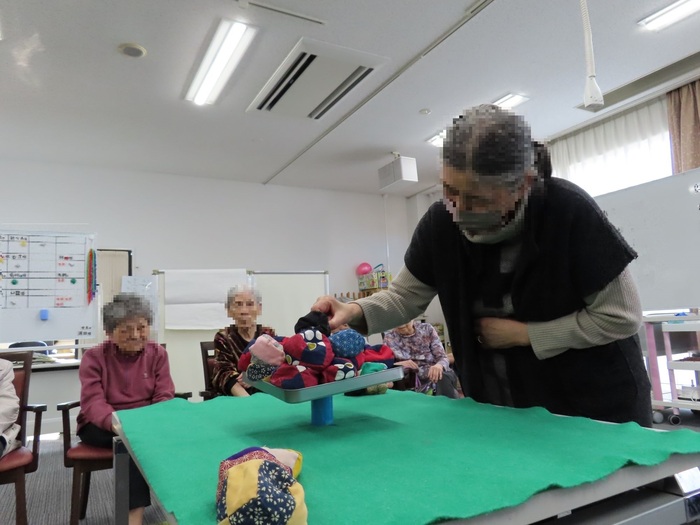 積み木崩しならぬ、お手玉崩し。棒の上に、お手玉が載ったプレートを置いて、お手玉を取っていきます。お手玉は中身が粒なのでバランス取りが難しいです。